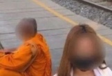 Bung hết cúc áo chụp ảnh khiêu gợi bên cạnh nhà sư, cô gái bị cảnh sát bắt giữ